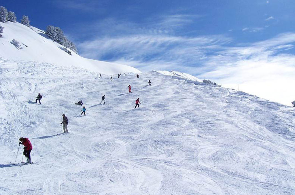People skiing down run in Courchevel, France