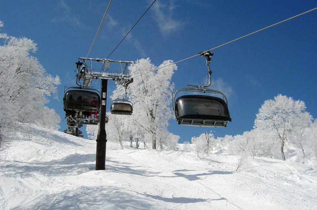 Skiers riding chairlift in Norzawa Onsen, Japan